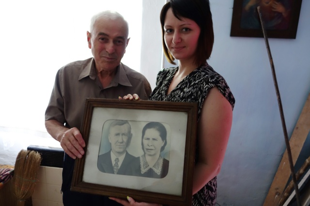 Mykhaylo and Lena holding an old portrait of Anton and Hanna Lobaj. Click to enlarge.